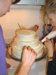 Edible pearl dragees were carefully placed, with a surgeon's care, between each dot of frosting around the base of the wedding cake layers.